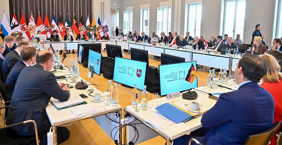 Ministerpräsidentenkonferenz (MPK) - Politikerinnen und Politiker sitzen an Tischen vor Bildschirmen mit Niedersachsenwappen